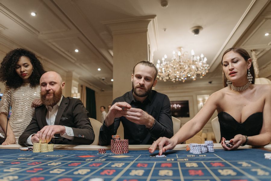Meja kerja dengan kartu remi dan alat tulis melambangkan kerja redaksi